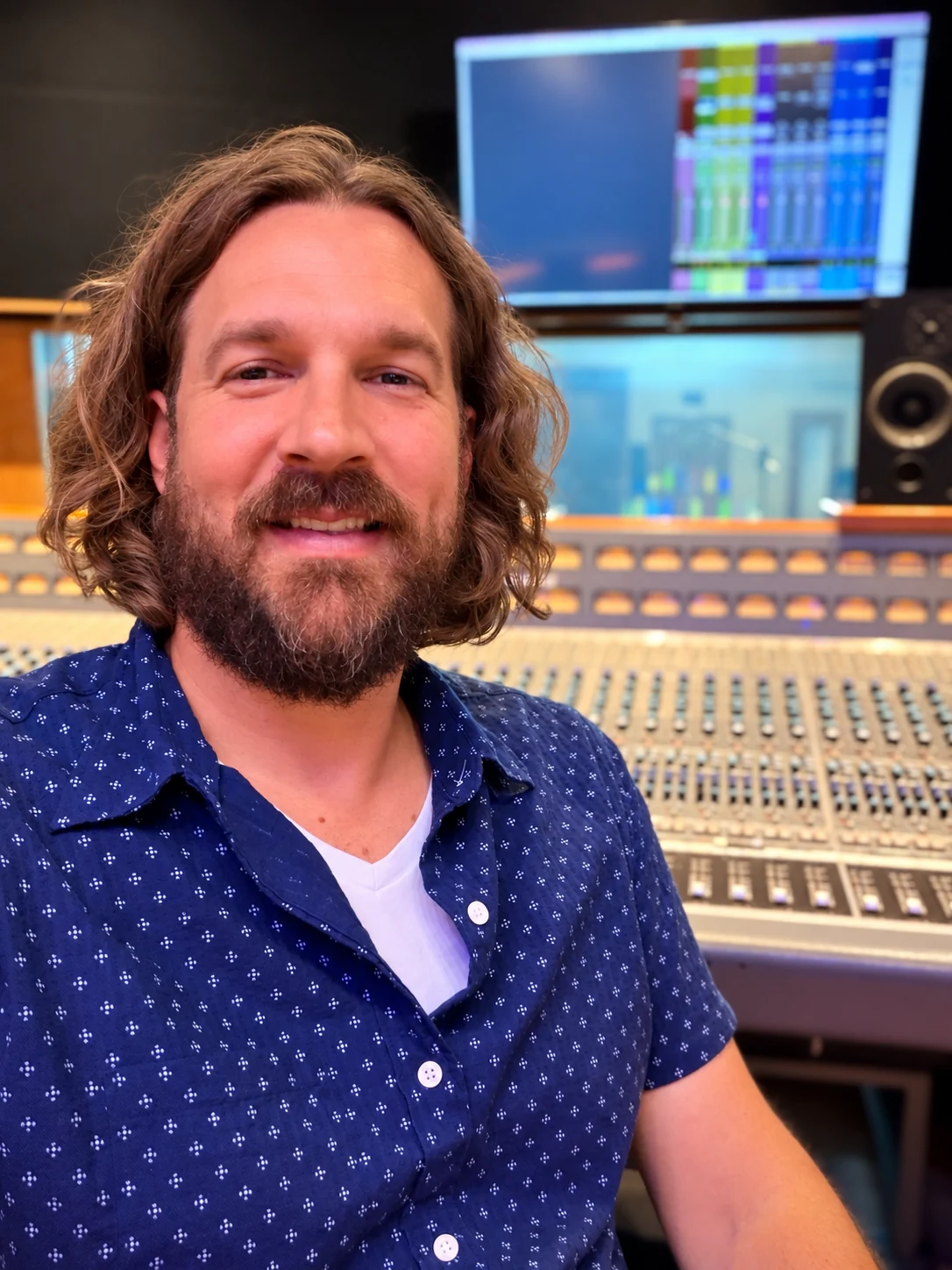 Garrett R. Miller seated at a studio mixing console